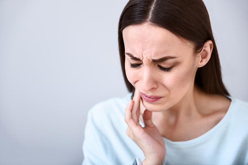 Cheerless woman having toothache
