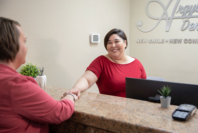 dental receptionist checking patient in