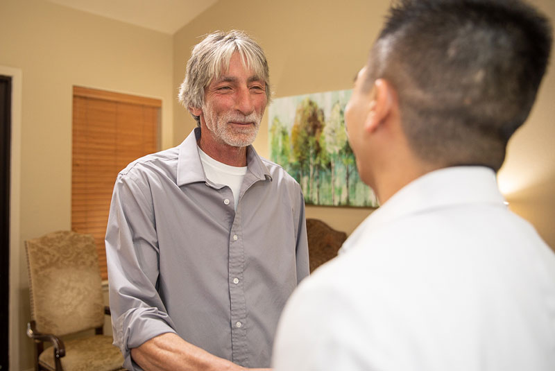 dental implant patient smiling and checking in