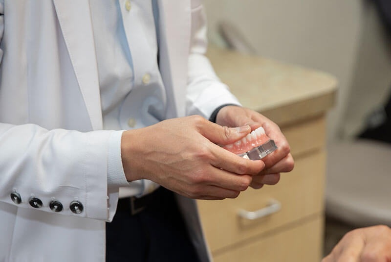 dr. hua holding model of dental implants