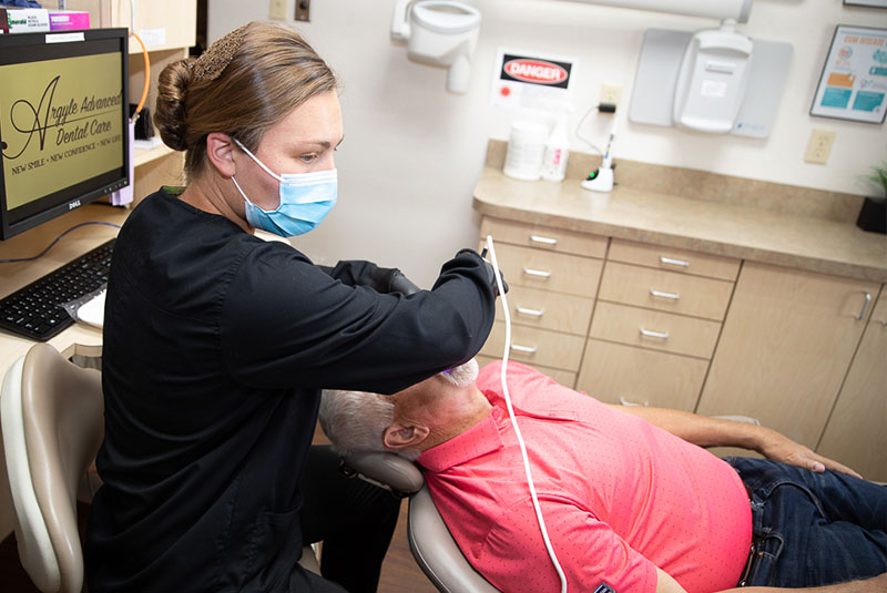 dental assistant scanning patient's teeth